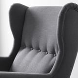 Elegantné kreslo s vonkajším operadlom zblízka, ktoré predvádza vysokokvalitnú látku. Detailné prešívanie a robustná konštrukcia.