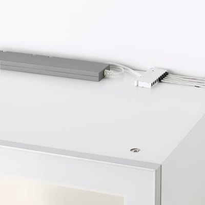 TRÅDFRI LED ovládač na bielom povrchu, káblový, ovláda inteligentné osvetlenie.