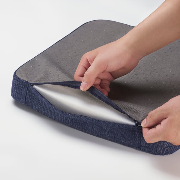 Person placing a grey cushioned seat pad, zipped, indicating quality design and easy maintenance.
