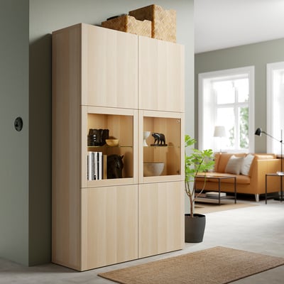 Oak BESTÅ storage with glass doors near window, displaying decor.