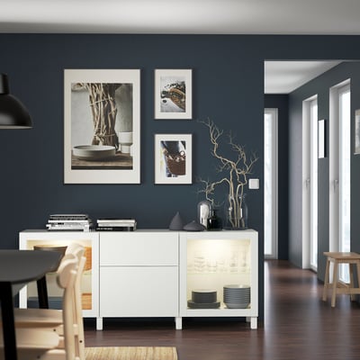 Modern dining room with BESTÅ sideboard, photos, and wooden table.