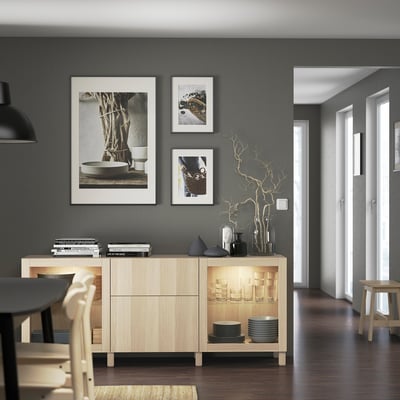Modern living room with light wood BESTÅ sideboard, dark grey wall, pendant light, and minimalist decor.
