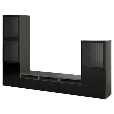 Black IKEA BESTÅ tv unit with modern design, long bench, drawers, shelves, and tall glass-door cabinets.
