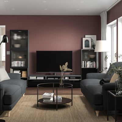 Modern living room with burgundy walls, grey sofas, BESTÅ tv bench, flat-screen tv.