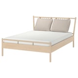 BJÖRKSNÄS bed in beige, light wood, rectangular, minimalist design with two pillows.