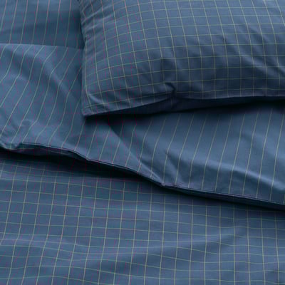 A stack of blue bedding items: a duvet cover and matching pillowcases, featuring a chequered pattern, made of 100% cotton.