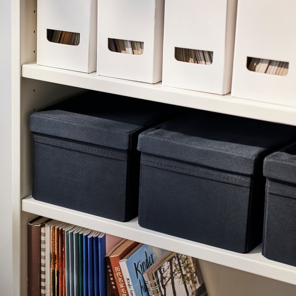 Shelf with grey fabric storage boxes and books.