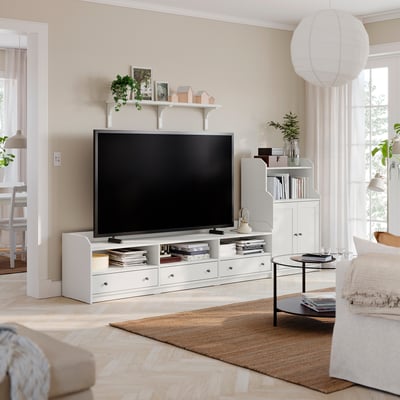 White HAUGA tv stand with shelves, drawers, flat-screen tv, minimalist decor.
