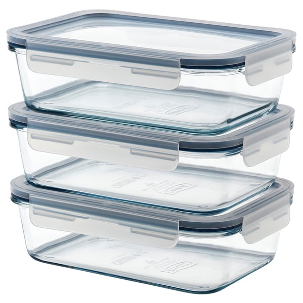 Three clear glass meal containers with blue lids stacked neatly.