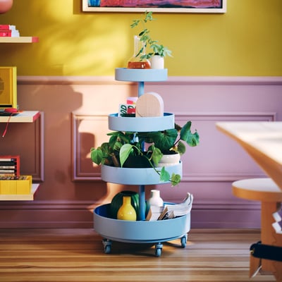IKEA PS 2026 blue storage trolley holds plants & decor, rolling on wheels. Round, tall, fits neat spaces.