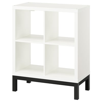 KALLAX white cube shelf, four square sections, black metal base, modern minimal design.