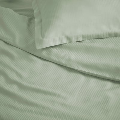 This image shows a neatly folded green LÄKEVÄNDEROT bedding set, featuring a soft, textured dobby pattern, with matching pillowcases.