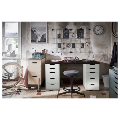 Home office with white desk, black chair, and wall decor.