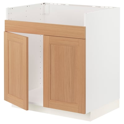 A white METOD kitchen cabinet with oak doors, featuring a modern design with natural wood grain.