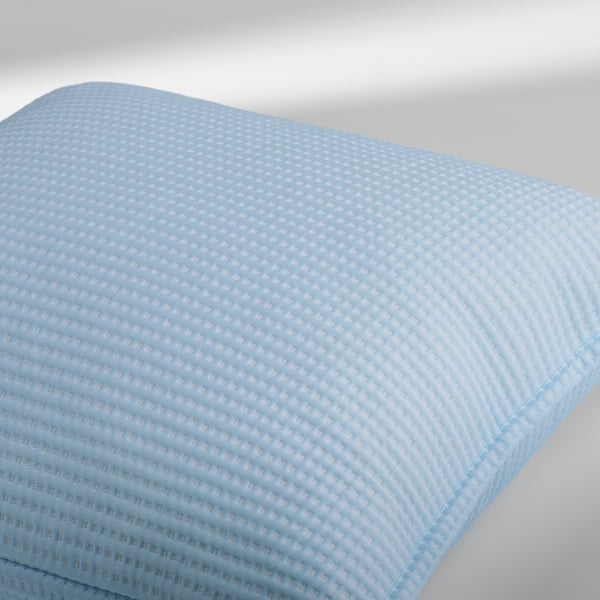 A soft, blue, textured pillow cover with a waffle weave pattern, designed for comfort and coolness.