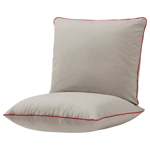 An beige outdoor cushion set with red piping. It is square-shaped and designed for comfort, fitting an armchair frame.