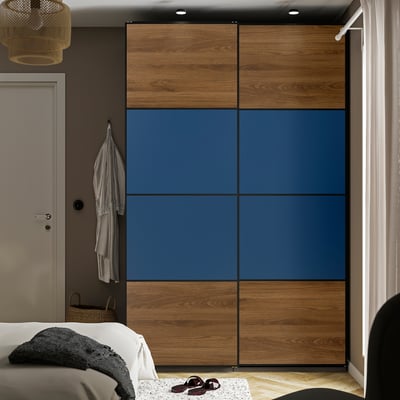 Modern bedroom with large floor-to-ceiling PAX wardrobe, blue and wood sliding doors, white bed, and minimalist decor.