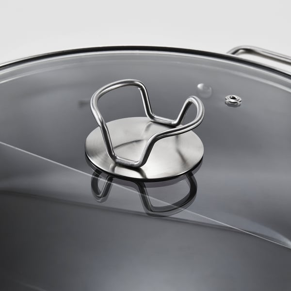 Close-up of a modern stainless steel pot lid with a robust, metallic handle, designed for even heat distribution and easy handling.