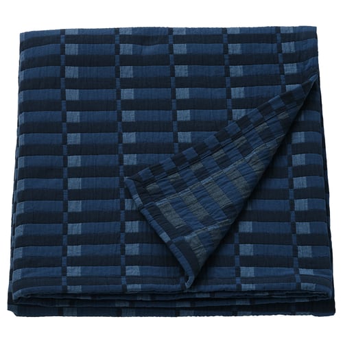 Ikea SKOGSKOVALL blue cotton blanket with dark lines folded.