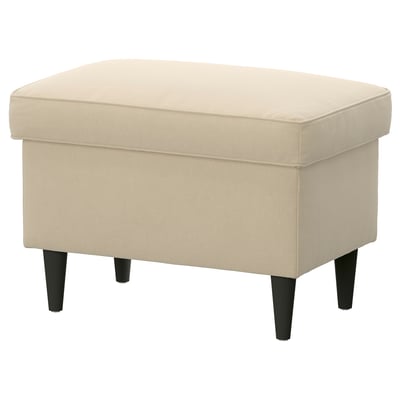 This image a beige STRANDMON footstool with a soft velour cover, plush cushion, and black wooden legs, designed for comfort and storage.