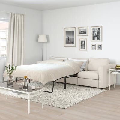 VIMLE sofa-bed in beige, versatile, with coffee tables & photos on neutral wall.