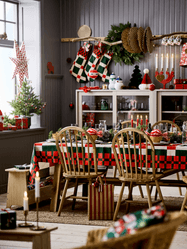 Festive dining room filled with Christmas decor. A table and chairs are in the center of the room with cabinets in the background