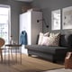 Modern living area with grey ÄLVDALEN sofa, rapid fold-out bed, beneath storage, near white cabinet, and round side table.