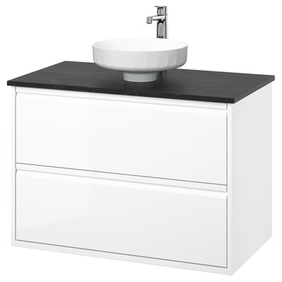 Modern white wall-mounted bathroom vanity with black marble countertop, round white basin, and chrome tap.