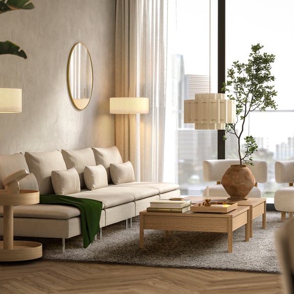 Modern living room with white sofa, wooden coffee table, and large ÄRENDE rug in light grey, covering most floor space.