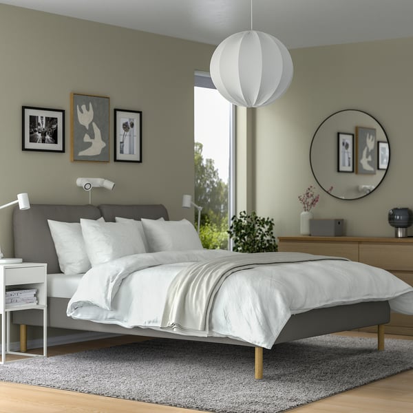 Modern bedroom with large grey ÄRENDE rug, white bed, wooden furniture, & green walls. Rug size: large.