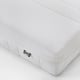 A corner of a firm memory foam mattress by IKEA, showing clean white, quilted fabric and a branded tag.
