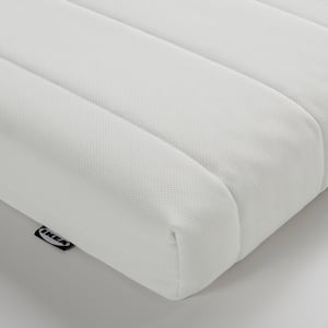 Close-up of a white, textured foam mattress showcasing its smooth, even surface and quality craftsmanship.