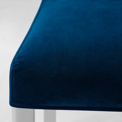 Close-up of plush, dark blue velvet chair. Soft, smooth texture, rich colour.