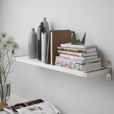A modern wall shelf holds books, vases, and decorations with bevelled and smooth edges for versatile styling.