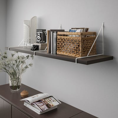Modern wall shelf, wooden with metal brackets, displays books, basket, and camera.