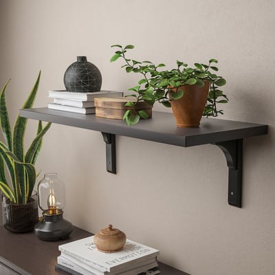 Wall-mounted shelf with books, plants, and decor. Holds items securely, ideal for bedroom or living room.