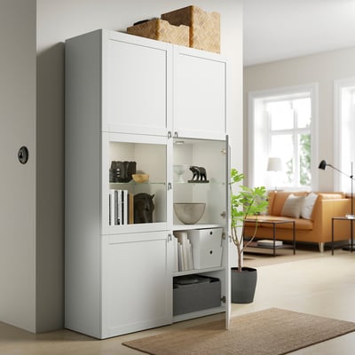 White BESTÅ cabinet displays and stores items. Glass doors showcase contents, while adjustable shelves organise within.