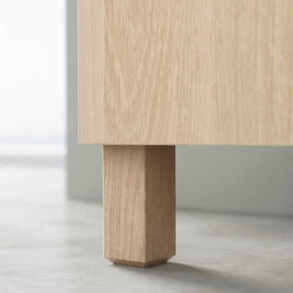 Light-colored wooden table leg, square shape, minimalist design.