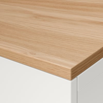Close-up of smooth, light oak wooden surface atop a white furniture piece, showcasing quality and craftsmanship.