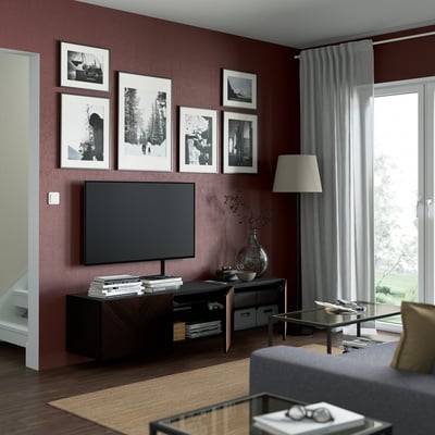 Modern living room with BESTÅ tv bench, flat-screen tv, shelves, glass coffee table, and art.