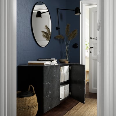 Modern entryway with wall-mounted cabinet, mirror, and lighting.