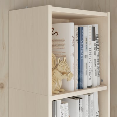 Wooden shelf unit with books and decorative item. Maximises wall storage.