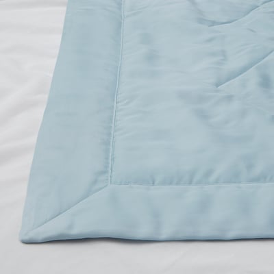 Light blue duvet cover on bed, smooth texture, neatly laid corner view.