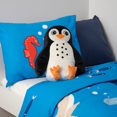 Penguin cushion on toddler bed, recycled polyester, BLÅVINGAD collection.