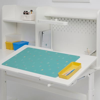 White desk setup with turquoise BÖNSYRSA pad, yellow container with art supplies, and storage bins on shelves.