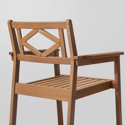 Well-crafted wooden chair with intricate back design and armrests, showcasing durable eucalyptus wood and quality craftsmanship.
