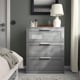A modern grey BRIMNES dresser with glass top drawer, lamp, and makeup.