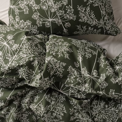 A deep green bedding set with white floral patterns, appearing soft and high-quality.
