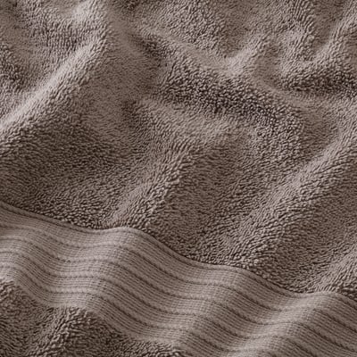 Soft, fluffy towel with intricate weave pattern, likely made of organic cotton, ensuring comfort and absorbency.