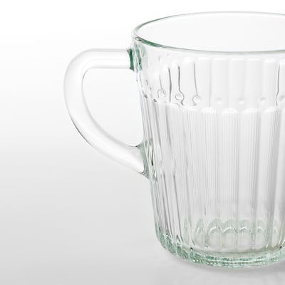 Clear glass mug with a sturdy handle, showcasing vertical ribbing for grip, standing on a plain surface.